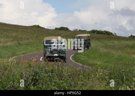 EIN PAAR VON LAND ROVER SERIE 1 FAHRZEUGE AUF EINER LANDSTRAßE Stockfoto