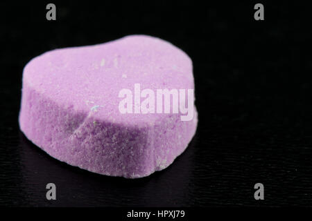 Angle View of leer lila Zuckerherz auf schwarzem Hintergrund Stockfoto