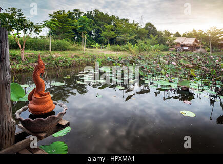 Schönen Teich mit Lotus und Drachen Statuen in Sukhothai Resort, Thailand Stockfoto