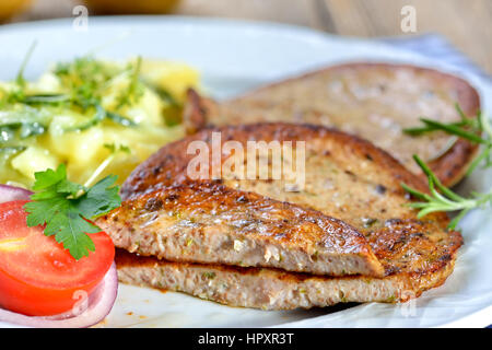 Bayerische Küche: gebratene Scheiben Wurst mit Stücken von Schwein Milz (so genannte "Milzwurst") serviert mit Kartoffelsalat Stockfoto