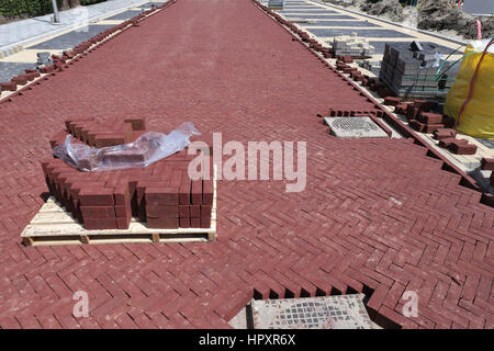 Palette mit Pflastersteinen auf Baustelle in Wohnzone Stockfoto