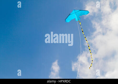 Drachen fliegen gegen den blauen Himmel an einem sonnigen Tag Stockfoto