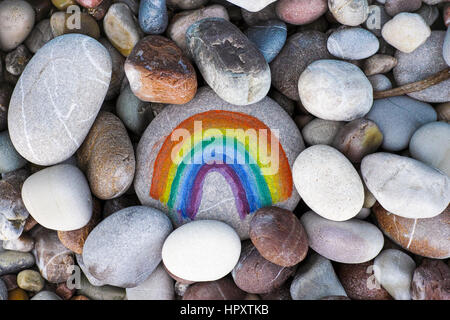 Regenbogen auf Kiesel mit Steinen Hintergrund gemalt. Close-up. Stockfoto