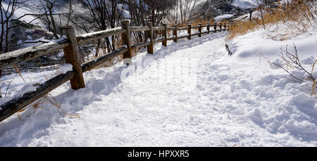 Schnee und geschwungenen Gehweg im Wald Noboribetsu Onsen Schnee Winter Nationalpark in Jigokudani, Hokkaido, Japan Stockfoto