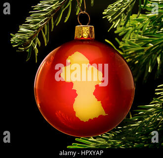 Eine Rote Christbaumkugel mit der goldenen Form von Guyana hängen an einem Weihnachtsbaum isoliert auf schwarz. (Serie) Stockfoto