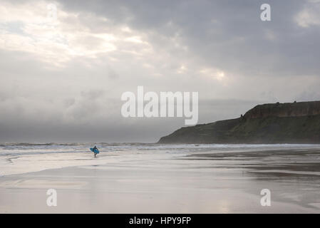 Surfer am Strand von Cayton Bucht in der Nähe von Scarborough, North Yorkshire, England. Eine beliebte Surf-Strand an der Nordostküste Englands. Stockfoto