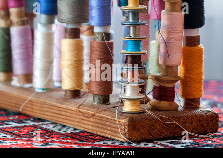 Mehrfarbige Nähgarne Vintage weiche Pastellfarben auf Spulen. Nähen-Schneider im Zusammenhang mit Zubehör. Stockfoto