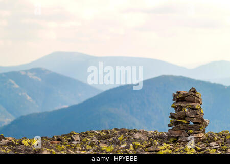 Cairns oder Rock Pfähle auf Berg mit Blick auf den Highlands. Pyramide aus Steinen. Stein-Turm. Stapel der Felsen Stein in Bergen. Stockfoto