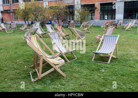 Sonnenliegen auf dem grünen Rasen. Sommer-Stuhl. Viele Sommer Stühle im Freien. Stockfoto