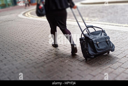 Frau, ziehen, Rollen Tasche entlang Pflaster Stockfoto