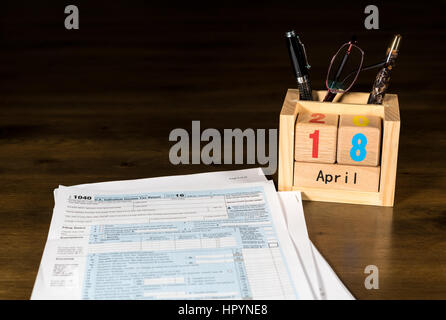 Holzbuchstaben in Kalender mit Formular 1040 Einkommensteuer für 2016 zeigt Steuer-Tag für die Einreichung ist 18. April 2017 Stockfoto