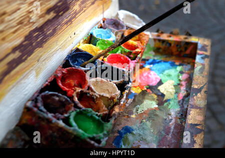 Künstler bei der Arbeit. Der Arbeitsplatz des Künstlers, Pinsel, Farben und Leinwand. Multicolor Ölfarben auf einer Palette hautnah. Stockfoto