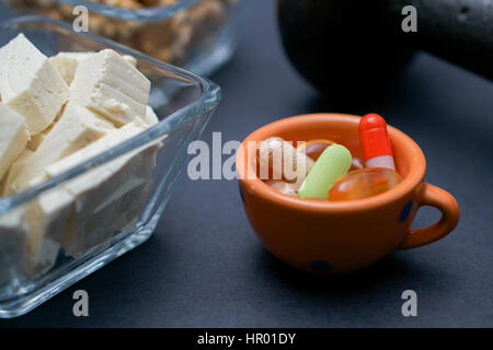 Closeup auf Hantel, Nussbaum, Tofu und Nahrungsergänzungen auf dunklem Hintergrund: Fitness und Gewicht-Verlust-Konzept. Stockfoto