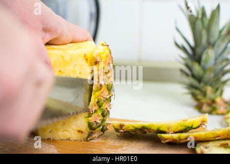 Männliche Hände frische Ananas Haut peeling hautnah Stockfoto