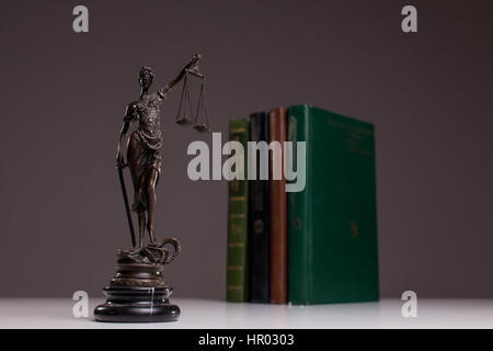 Statuette der Themis das Symbol des Gesetzes über die alten Holzboden mit zugelassenen Codes. Stockfoto