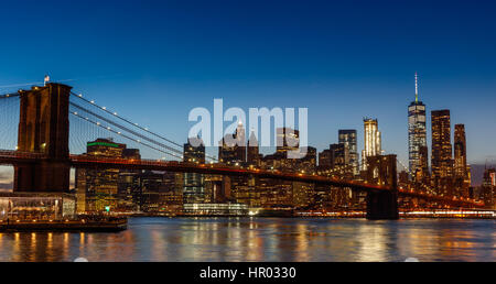 Eine Nachtaufnahme von einem beleuchteten Brooklyn Bridge mit einer Skyline von Manhattan Stockfoto