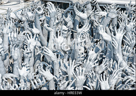 Der weiße Tempel, Wat Rong Khun, Chiang Rai, Thailand.  Die Hände bis symbolisiert hemmungslose Lust. Stockfoto