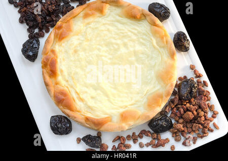 Sahne und getrockneten Früchten auf ein Hacken von Board und einen schwarzen Hintergrund. Stockfoto