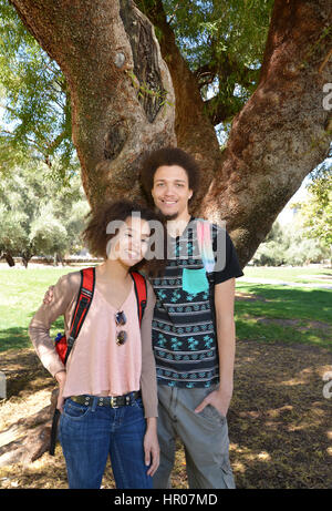 Eine junge Frau und Mann posieren für ein Porträt über eine Hochschule Campus, University of Arizona, Tucson, USA. Stockfoto