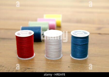 Mehrfarbige Baumwolle Walzen oder Spulen auf einem Tisch aus Holz Handarbeit Stockfoto