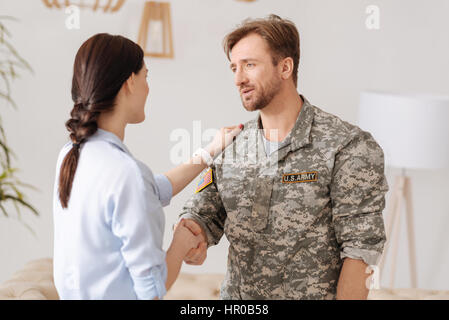 Sie hat mir sehr geholfen. Positiv erfreut militärischen Mann lächelnd und geben einen Händedruck zu seinem Psychologen beim beendete die psychologische session Stockfoto