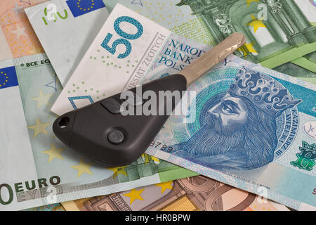 Autoschlüssel auf polnischen Zloty und Euro-Banknoten Hintergrund closeup Stockfoto