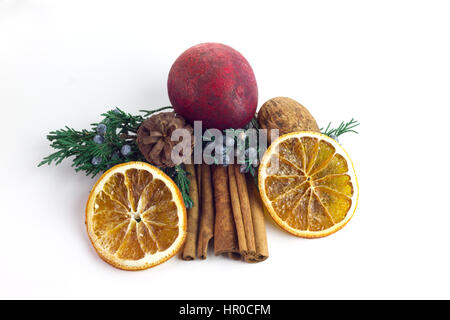 Zimt-Sticks umgeben von Potpourri, Orangenscheiben, Tannenzweigen, Beeren und Nüssen isoliert auf weißem Hintergrund Stockfoto