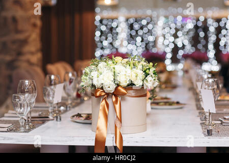 Hut mit Blumen close-up. Hochzeit. Und Veranstaltungsräume. Die Tische und Stühle für Gäste, serviert mit Besteck und Geschirr Stockfoto