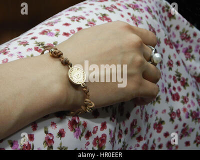 Mädchen und Hand mit der Münze-Armband Stockfoto
