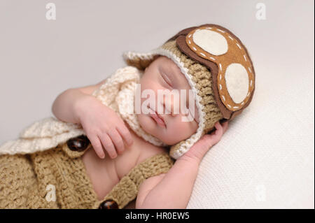 Schlafen zwei Wochen alten neugeborenen Jungen einen gehäkelten Flieger Hut mit Brille.