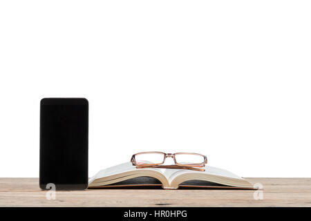 Smartphone neben dem offenen Buch und Brille liegen auf einem Holztisch isoliert auf weißem Hintergrund Stockfoto