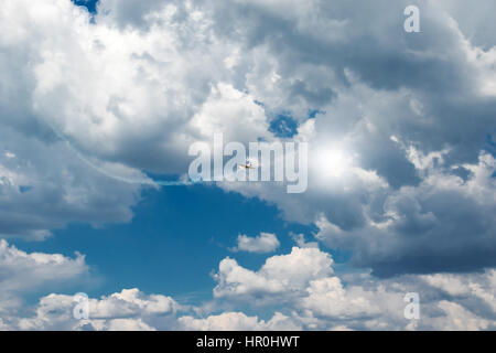 Weiße Flugzeug fliegt in den blauen Himmel mit Wolken jetten Rauch Stockfoto