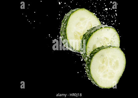 Drei Scheiben grüne Gurke gewickelt in den Sprechblasen auf schwarzem Hintergrund isoliert Stockfoto