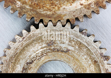 alte, verschlissene Getriebe Zahnräder mit Rost auf zerkratzten Metall Hintergrund Makro Stockfoto