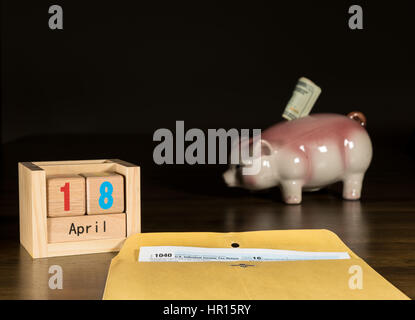 Holzbuchstaben in Kalender mit Formular 1040 Einkommensteuer für 2016 zeigt Steuer-Tag für die Einreichung ist 18. April 2017 mit Piggy Sparkasse im Hintergrund Stockfoto
