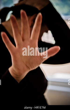 zarte Frauenhand in schützenden Geste Stockfoto