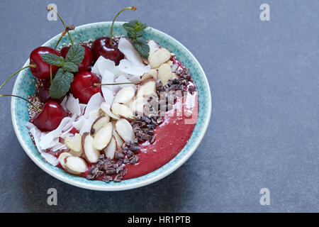 Smoothie-Schüssel garniert mit Kirsche, Kokos und Mandel Stockfoto