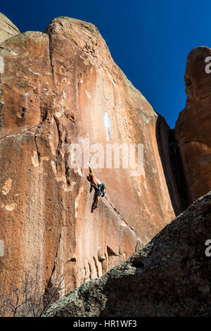 Junger Mann Klettern von der Jungfrau von Guadalupe Malerei; Penitente Canyon; Colorado; USA Stockfoto