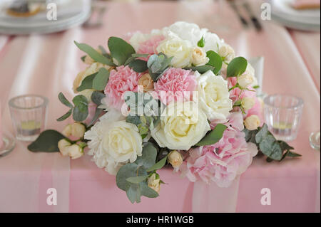 Hochzeitstafel mit Blumenstrauß und Kerzen dekoriert Stockfoto