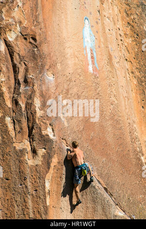 Junger Mann Klettern von der Jungfrau von Guadalupe Malerei; Penitente Canyon; Colorado; USA Stockfoto