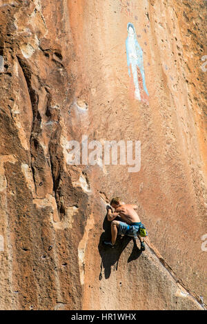 Junger Mann Klettern von der Jungfrau von Guadalupe Malerei; Penitente Canyon; Colorado; USA Stockfoto