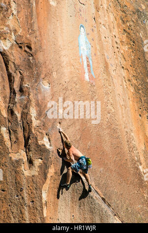 Junger Mann Klettern von der Jungfrau von Guadalupe Malerei; Penitente Canyon; Colorado; USA Stockfoto