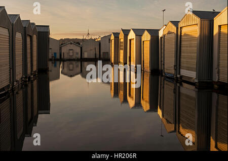 Sunrise Bootshäuser in Reihen entlang der Uferpromenade am Puget Sound Stockfoto