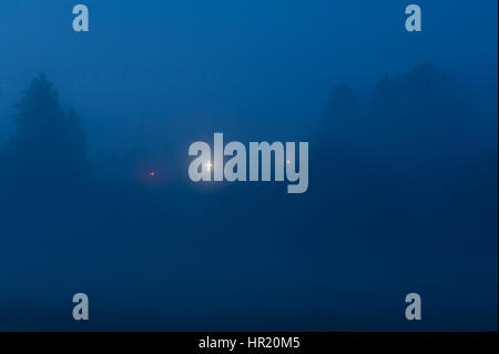 Weißen Neon beleuchtete Kreuz im Morgennebel Stockfoto