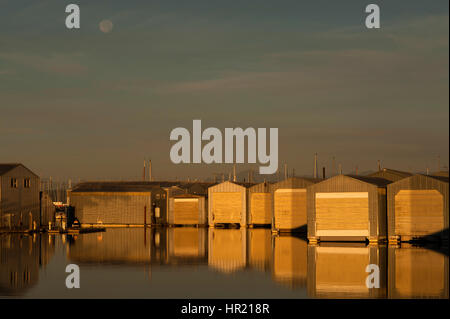 Bootshaus Reflexionen in Reihen entlang der Uferpromenade am Everett Marina mit mondaufgang. Stockfoto