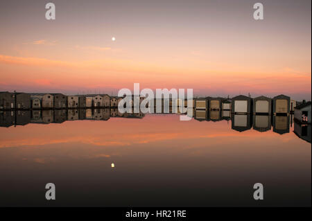 Bootshaus Reflexionen in Reihen entlang der Uferpromenade am Everett Marina mit mondaufgang. Stockfoto