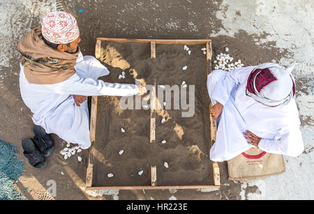 Muscat, Oman - 4. Februar 2017: Zwei gekleidet traditionell omanischen Männer spielen ein traditionelles Spiel. Stockfoto