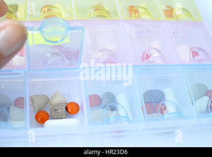 Detailansicht des transparenten Kunststoff Pille Organizer öffnen mit Drogen im Inneren für eine wöchentliche Dosierung. Selektiven Fokus. Stockfoto