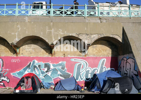 Zelte von Obdachlosen gegen Graffiti auf Brighton Meer Stockfoto