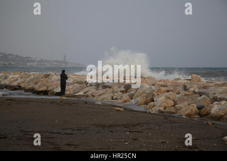 Ein Junge auf der Suche trifft eine große Welle einen Wellenbrecher. Malaga. Spanien Stockfoto